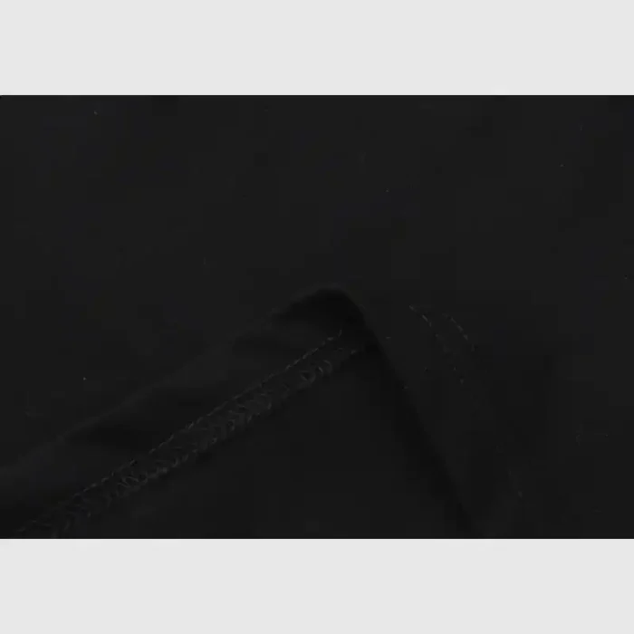 Close-up of the black Hellstar Path To Paradise T-Shirt fabric, showcasing visible stitching and a folded edge against a light gray background. The texture and seam detail emphasize the high-quality material and craftsmanship.