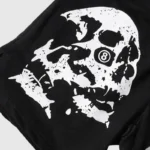 Hellstar Studios Shorts in black feature a distinctive white skull design that creatively incorporates an 8 ball, forming a unique and edgy pattern against the dark backdrop.